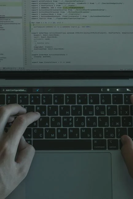 A laptop on a bed showing web design software, creating a cozy workspace.